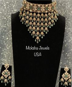 the necklace and earring set is displayed on a black mannequin with gold flowers