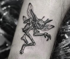 a black and white photo of a person with a tattoo on their leg that has an image of a cartoon character