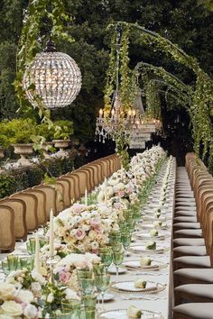 a long table is set up with flowers and candles for an elegant dinner party in the garden