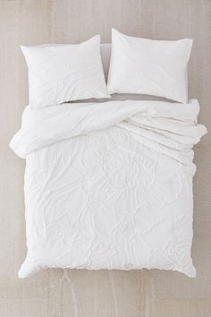 an image of a bed with white sheets and pillows on the bottom right hand corner