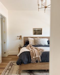 a bedroom with a bed, rug and two lamps on the side of the room