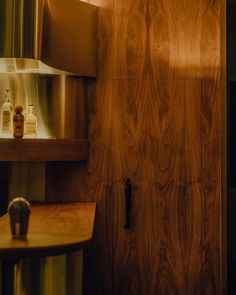 a wood paneled room with bottles on the shelf and a light fixture in the corner