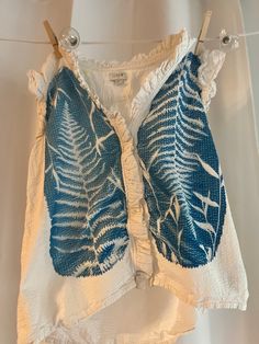 This unique piece was created using the traditional cyanotype method, a process dating back to the 19th century. Each item is made by hand and tells its own story through the vibrant blue tones and delicate white contrasts.  First, I prepare the surface (fabric or paper) with a photosensitive solution made from ferric ammonium citrate and potassium ferricyanide. After drying, I carefully arrange natural elements like leaves, flowers, negatives, or intricate stencils on the surface. Then, I expose the piece to sunlight, allowing the UV rays to imprint the design. Once exposed, I rinse the material in water to reveal the rich, indigo hues characteristic of cyanotypes.  Because each piece is sun-developed, no two prints are exactly alike, making this item a one-of-a-kind addition to your art Blue Hand Dyed Bohemian Tops, Bohemian Hand-dyed Blue Tops, Hand Dyed Blue Bohemian Tops, Blue Bohemian Hand Dyed Top, Plants Unique, Upcycling Clothing, Boho Aesthetic, Real Plants, Vibrant Blue