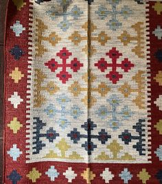 a red and yellow rug with crosses on it