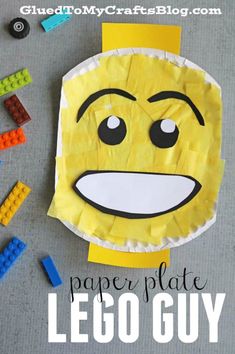 a paper plate with a face made out of legos next to some colored blocks