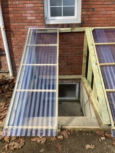 an open window on the side of a brick building with plastic coverings around it