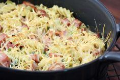 a skillet filled with pasta and ham