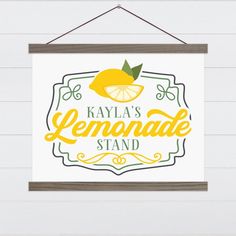 a lemonade stand sign hanging on a wall next to a white wooden planked wall