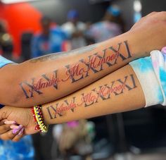 two people with tattoos on their arms holding each other's hands and armbands