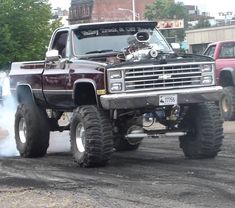 a large truck with big tires driving down the road