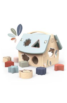 a wooden toy house surrounded by blocks and shapes