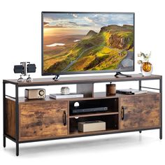 a flat screen tv sitting on top of a wooden entertainment center next to a vase