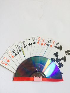 four playing cards and a cd in front of a white background