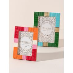 two multicolored frames sitting next to each other on a white surface with an ornate design in the middle