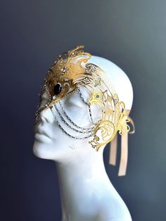 Step into the realm of goddesses with our women's masquerade mask in gold. Rhinestones delicately embellish the mask, adding a touch of sparkle. Silver chains gracefully adorn the mask, creating an enchanting movement. Capture attention at any masquerade party, ball, or themed event!


Age Group/Gender - Adult/Women

Size/Type - One size fits all adults

Mask Color - Gold

Mask Material - Laser Cut Metal

Special Features - Chains and rhinestones Ball Room Mask, Fairy Masquerade Mask, Angel Mask Masquerade Ball, Warrior Mask, Fairy Mask, Vintage Mask, Gold Fantasy Masquerade Mask For Carnival, Masquerade Mask Aesthetic, Luxury Traditional Gold Masquerade Mask