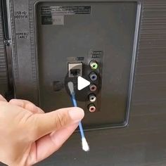 a person is holding a toothbrush in front of an electrical panel with wires attached to it