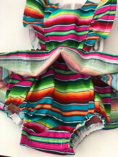 Perfect for all the summer 🥳 FIESTAS!! Handmade skirt romper. Made with cotton serape cotton fabric. These amazing pieces are made to order. Sizes 0-6 month up to 4T are made with attached bloomers and snaps at the saddle. Anything above a 4t (5t -7/8y) are the same style dress with no bloomers attached. If you have any questions on sizing please don't hesitate to message me. I will gladly help. Rainbow Cotton Dress For Playtime, Rainbow Cotton Playtime Dress, Playful Rainbow Cotton Dresses, Fun Rainbow Summer Dresses, Multicolor Dress For Cinco De Mayo Fiesta, Rainbow Summer Dress For Playtime, Rainbow Summer Dresses For Playtime, Fun Multicolor Sundress For Playtime, Cute Rainbow Dress For Summer