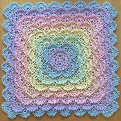 a crocheted square on top of a wooden table