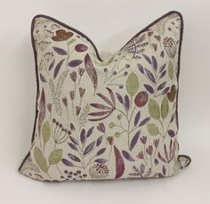 a white pillow with purple and green flowers on it