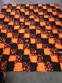 an orange and black quilt on the floor