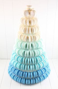 a stack of macaroons sitting on top of each other in shades of blue and white