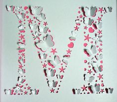 the letter m is made out of paper and cut into smaller shapes with pink flowers