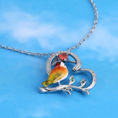 Designed for the free-spirited, the kingfisher is symbolic of freedom, courage, adventure, and balance. Each piece has been delicately hand-painted, displaying the uniqueness of its bright yellow feathers and orange plumage against a silver base. It is a true gift to spot one of these elusive creatures in nature.Carat Weight: 0.341 ctStone Size: 1,3*3,0.8 mmStone Type: Jeulia® StoneNumber of Stones: 44 Stone Shape: Round, HeartStone Color: Diamond White, Garnet RedChain Type: Cable chainWeight: Nature-inspired Multicolor Jewelry Gift, Nature-inspired Artistic Jewelry Gift, Nature-inspired Artistic Jewelry For Gifts, Whimsical Artistic Design Jewelry Gift, Whimsical Artistic Design Jewelry For Gift, Whimsical Artistic Jewelry For Gifts, Whimsical Bird Design Jewelry For Gifts, Whimsical Bird Design Jewelry For Gift, Enamel Jewelry With Bird Design For Gifts