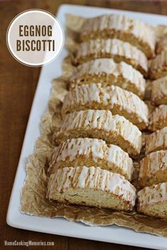 a white plate topped with frosted pastries on top of a wooden table