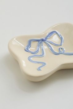 a white and blue dish with a bow on it