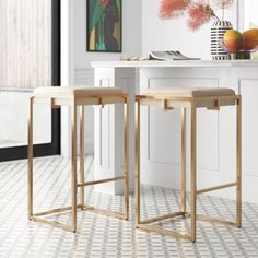 two stools sitting next to each other in front of a kitchen counter with flowers on it