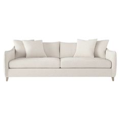 a white couch with four pillows on top of it and one arm folded back to the side