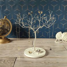 a white tree on a wooden table next to a globe and other items in the background