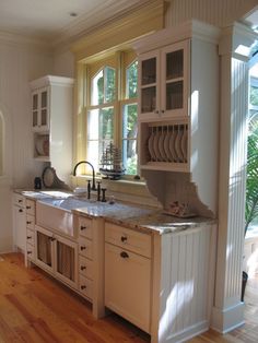 a kitchen with wooden floors and white cabinets