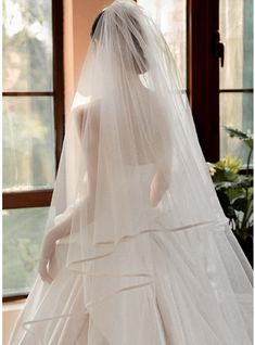 a woman in a white wedding dress and veil