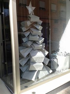 an image of a christmas tree made out of boxes in a store window with the caption'visit verizon lite '