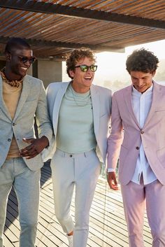 three men in suits and sunglasses walking together