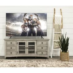 a large television mounted to the side of a wooden cabinet in front of a white wall