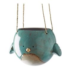 a teal ceramic dolphin planter hanging from chains