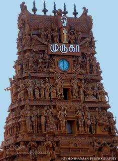 a tall clock tower with statues on it's sides and the word india written in large letters