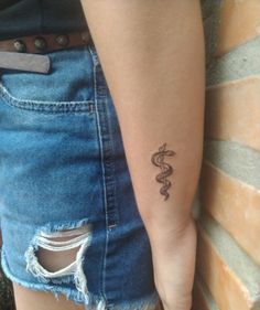 a woman's arm with a tattoo on it and a snake in the middle