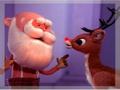 a santa clause holding onto a reindeer's nose