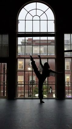 a person standing in front of a window with their arms up and one hand out