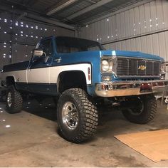 a large blue and white truck parked in a garage