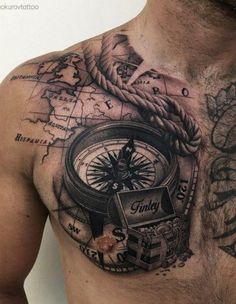 a man with a compass tattoo on his chest is looking down at the map he has drawn