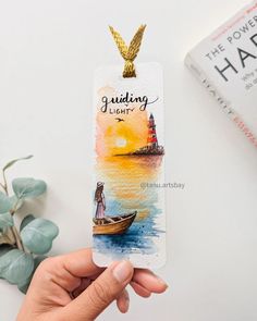 a person holding up a bookmark with the words guiding light on it