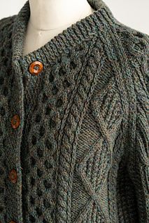 a knitted sweater with buttons on the collar