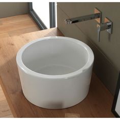 a white bowl sink sitting on top of a wooden counter next to a window with glass panes