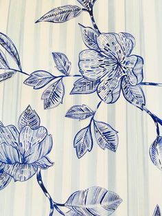 a blue and white wallpaper with flowers on it