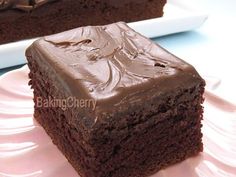 two pieces of chocolate cake sitting on top of a pink plate next to each other