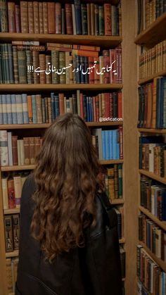 a woman standing in front of a book shelf filled with books